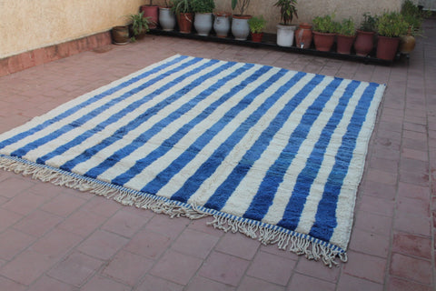 Side view of a blue striped Moroccan rug showcasing its textured surface.