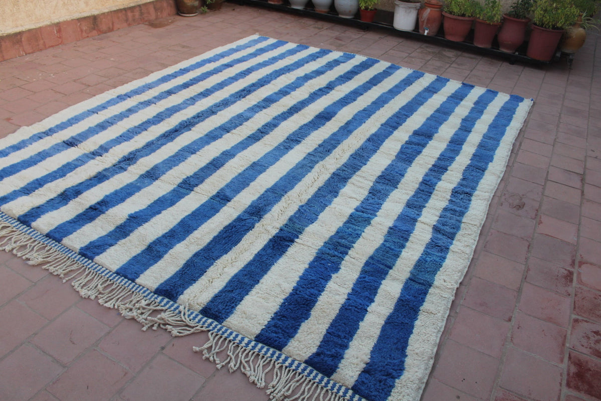 Side view of a blue striped Moroccan rug highlighting the striped pattern.