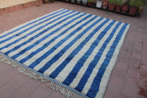 Side view of a blue striped Moroccan rug highlighting the striped pattern.
