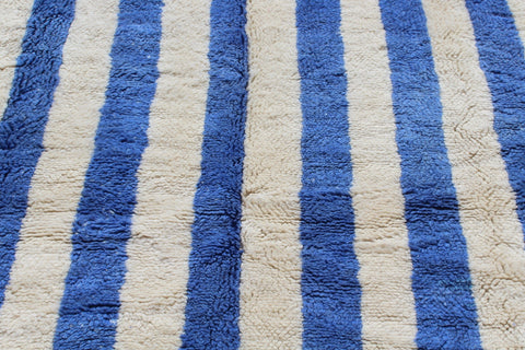 Detail shot of a blue striped Moroccan rug emphasizing its textured surface.