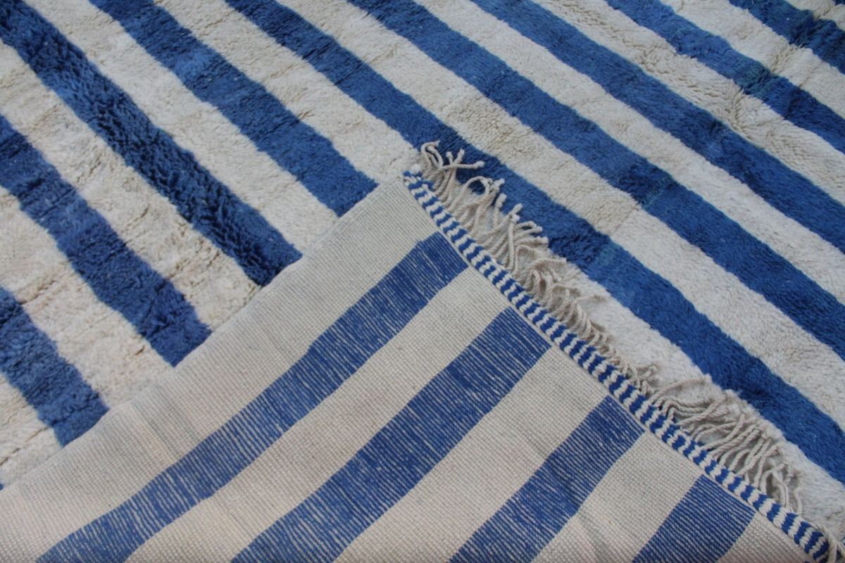 Close-up of a blue striped Moroccan rug with a woven texture.