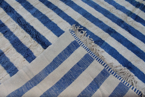 Close-up of a blue striped Moroccan rug with a woven texture.