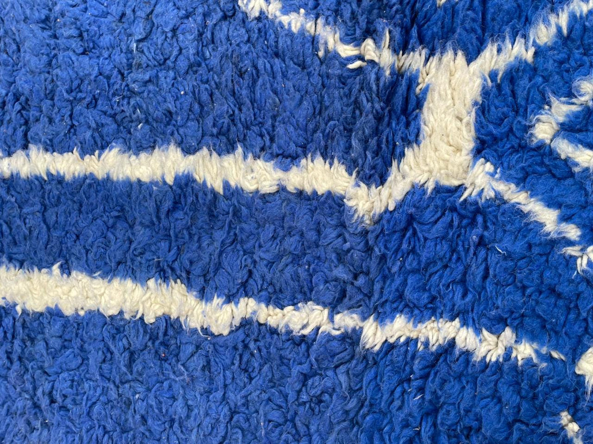 Detail of the abstract design on the blue vintage Moroccan rug set against a solid background.