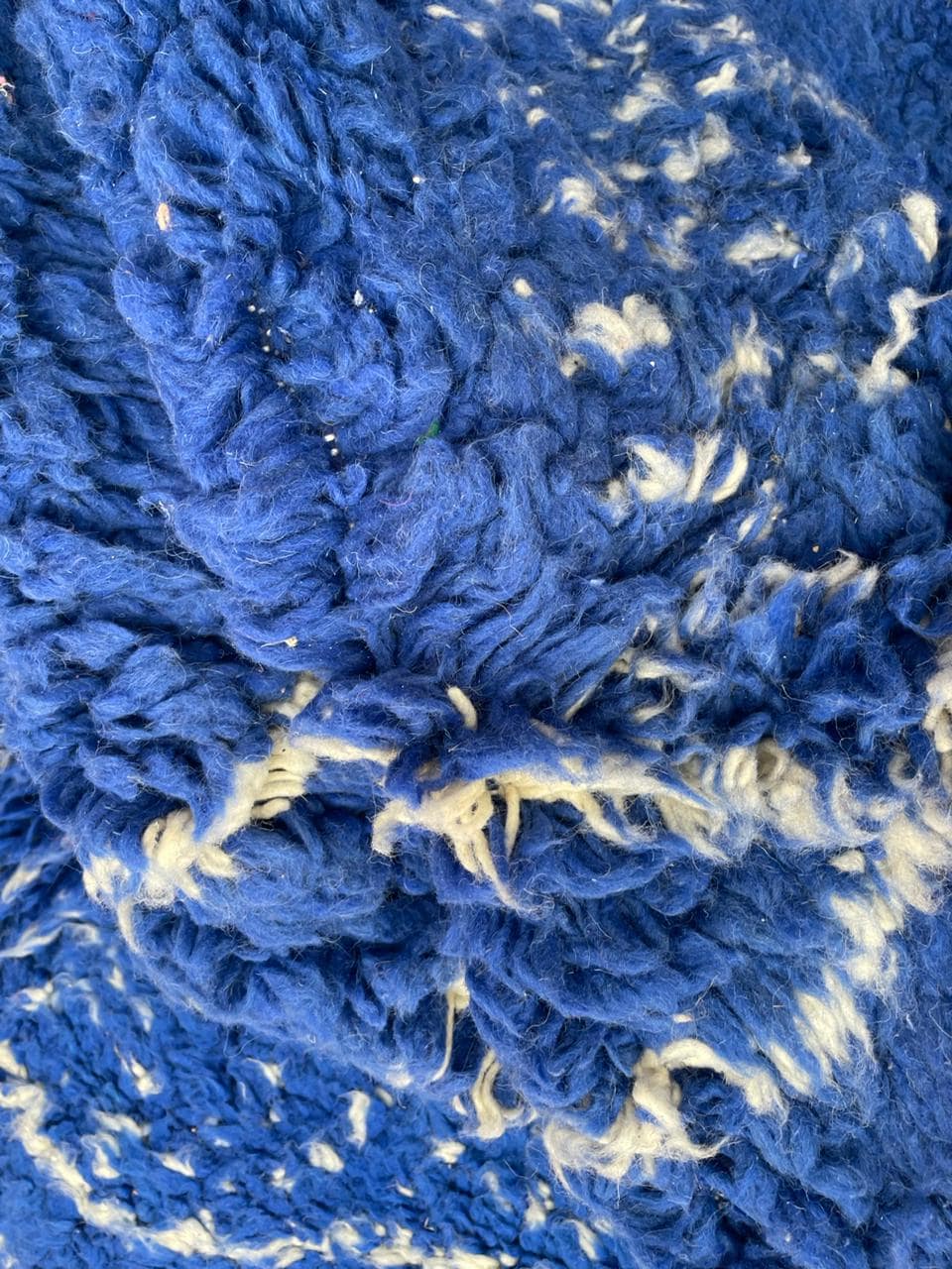 Close-up of the textured surface and tribal design on the blue vintage Moroccan rug.