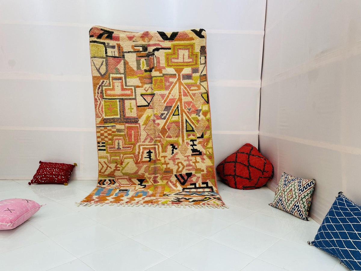 Lifestyle shot of the orange abstract Moroccan rug with vibrant colors in a studio setting.