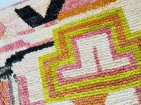Close-up detail of the orange abstract Moroccan rug featuring vibrant geometric designs.