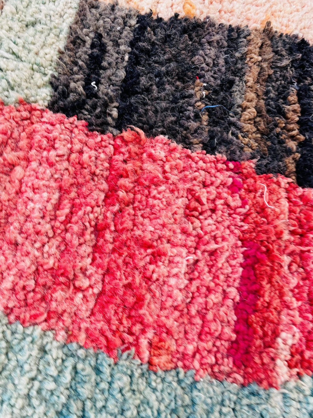 Close-up detail of a pink and black Moroccan rug showcasing an abstract pattern.