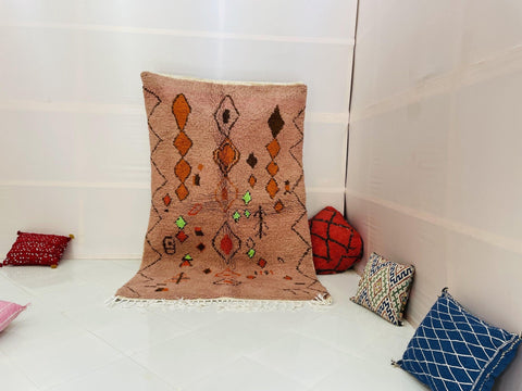 Lifestyle shot of the orange geometric Boujaad Moroccan rug with abstract patterns on a white background.