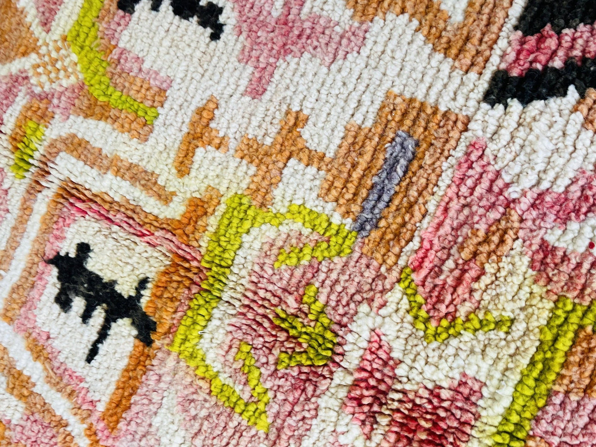 Close-up view of the abstract Moroccan rug in orange and pink with geometric features.