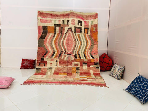 Lifestyle shot of an orange Moroccan rug featuring an abstract design on a white background.