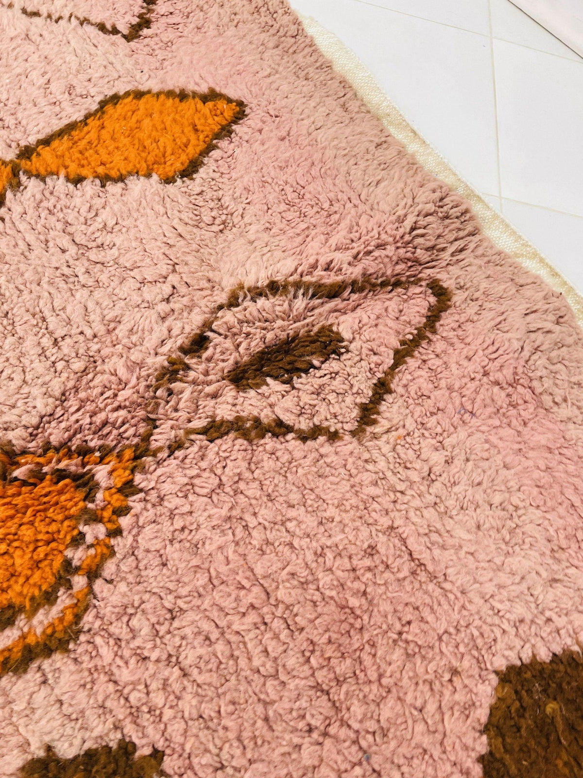 Close-up detail of the orange geometric Boujaad Moroccan rug highlighting its abstract patterns and vibrant colors.