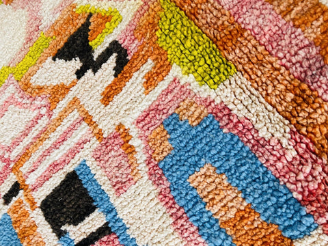 Detail shot of the orange abstract Moroccan rug displaying geometric patterns and colors.