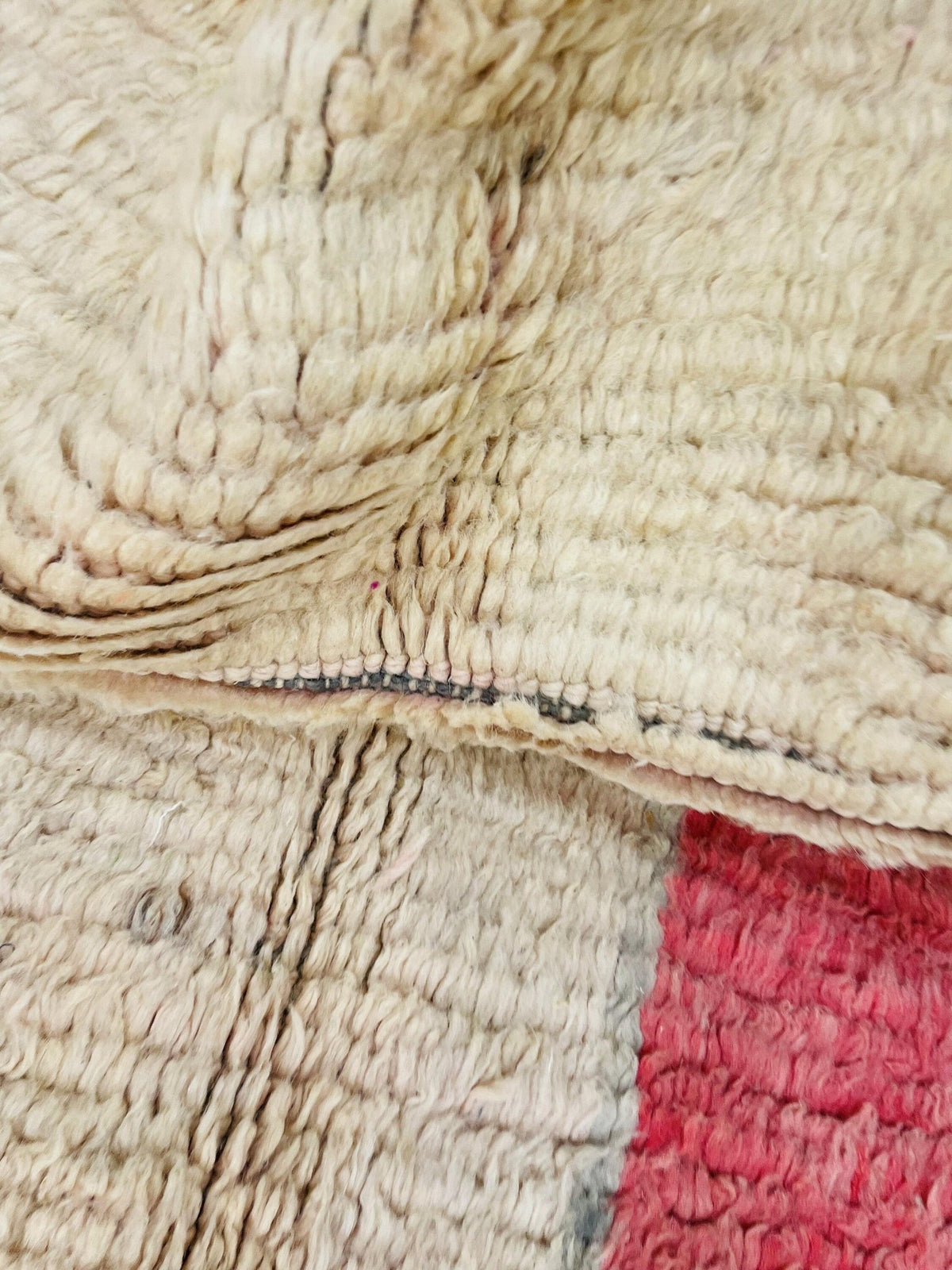 Top view of a pink abstract Moroccan rug showcasing its fringed edges and colorful design.