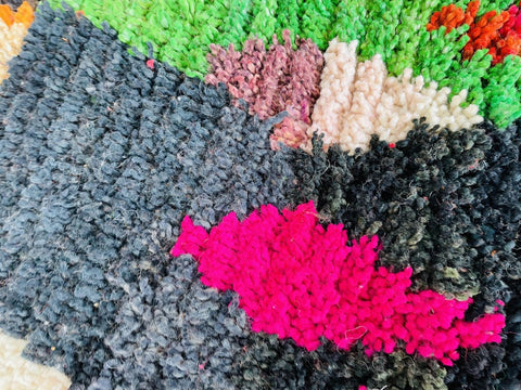 Detailed view of the rug highlighting its abstract design with purple, pink, and black colors.