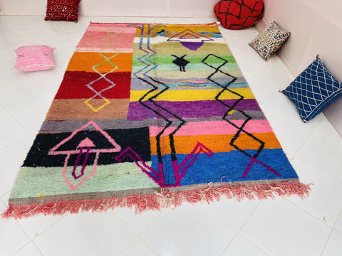 Lifestyle shot of a purple and pink abstract Moroccan rug showcasing vibrant colors.