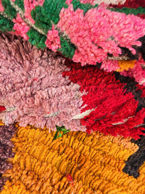 Close-up of colorful wool fibers in shades of pink, red, and yellow.