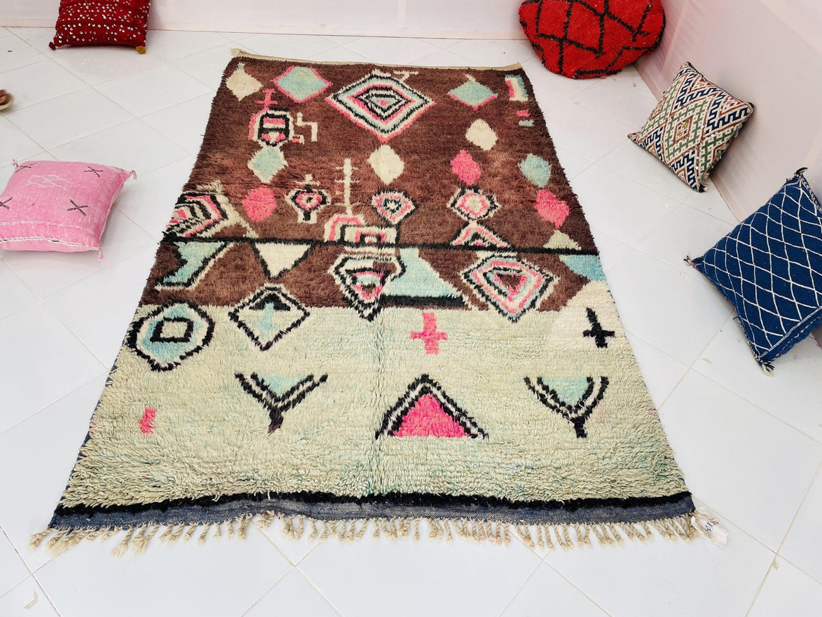 Lifestyle view of a geometric Boujaad Moroccan rug featuring brown, pink, and green colors.