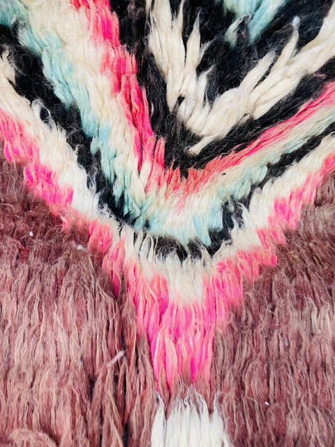 Detail close-up of the woven edge of a Boujaad Moroccan rug with colorful patterns.