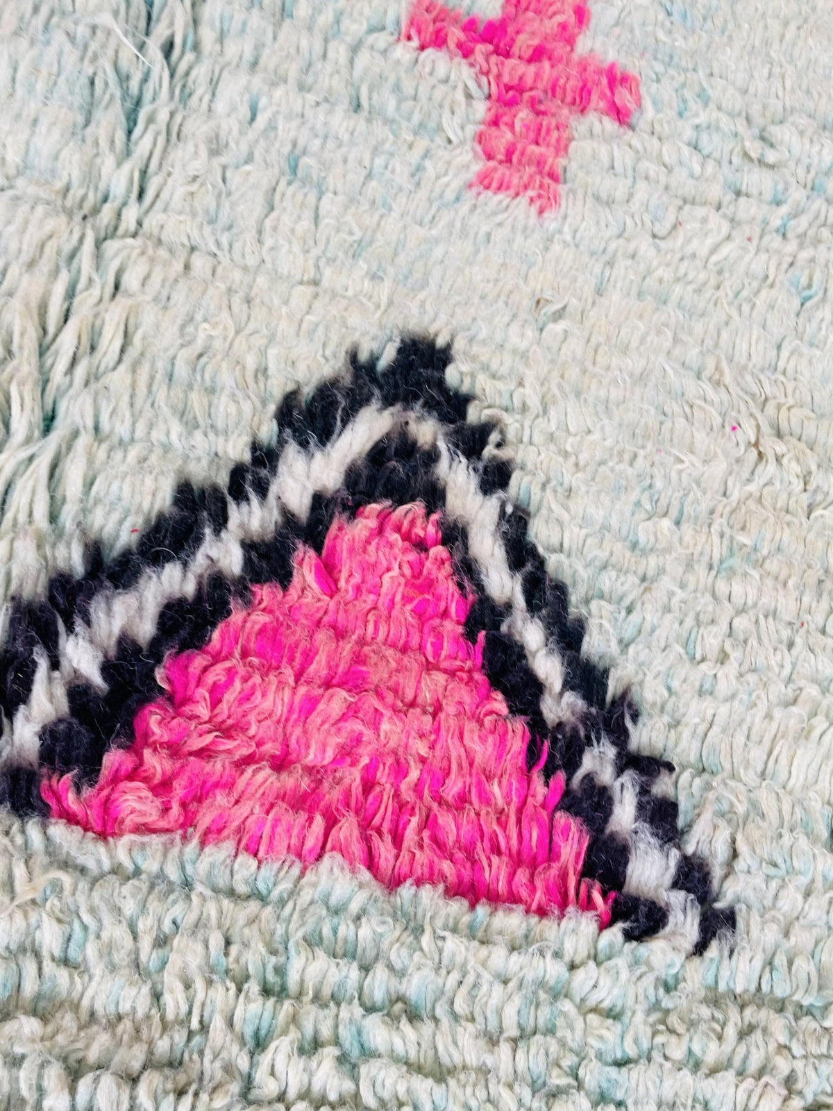 Detail shot showcasing the abstract design of a Boujaad Moroccan rug in purple and pink.
