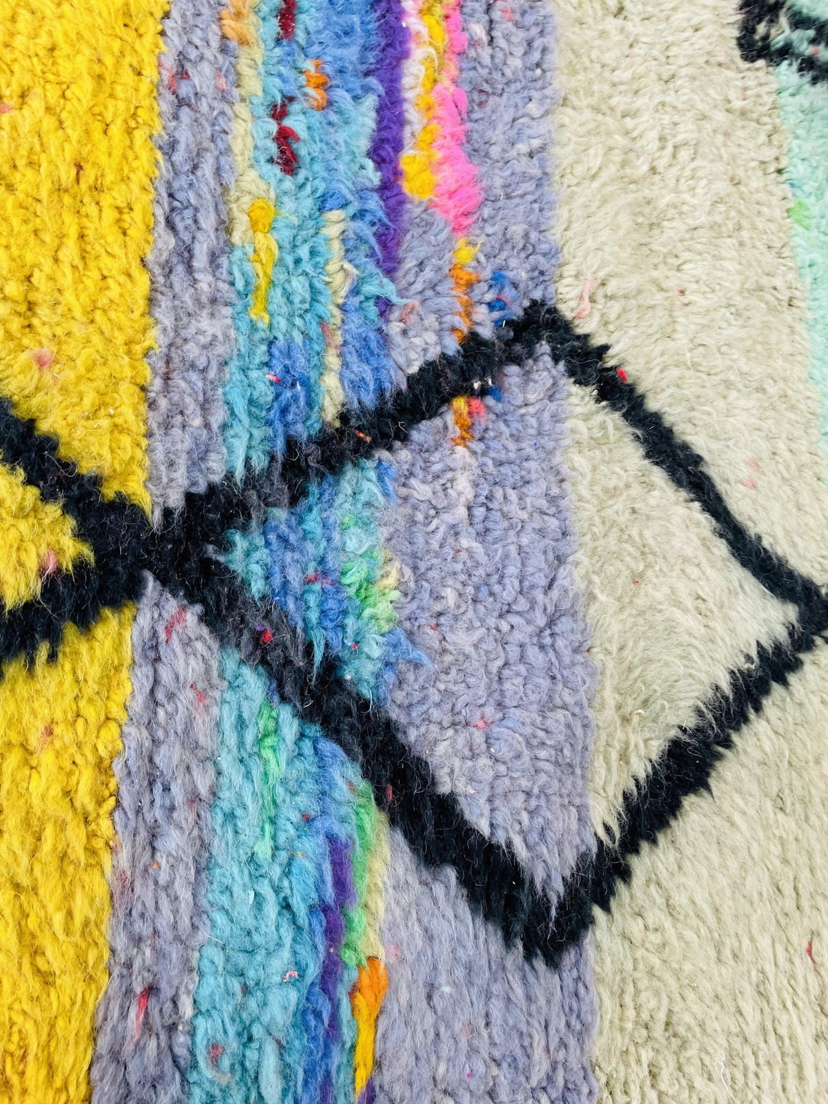 Close-up of a colorful abstract pattern featuring yellow and blue on a Moroccan rug.