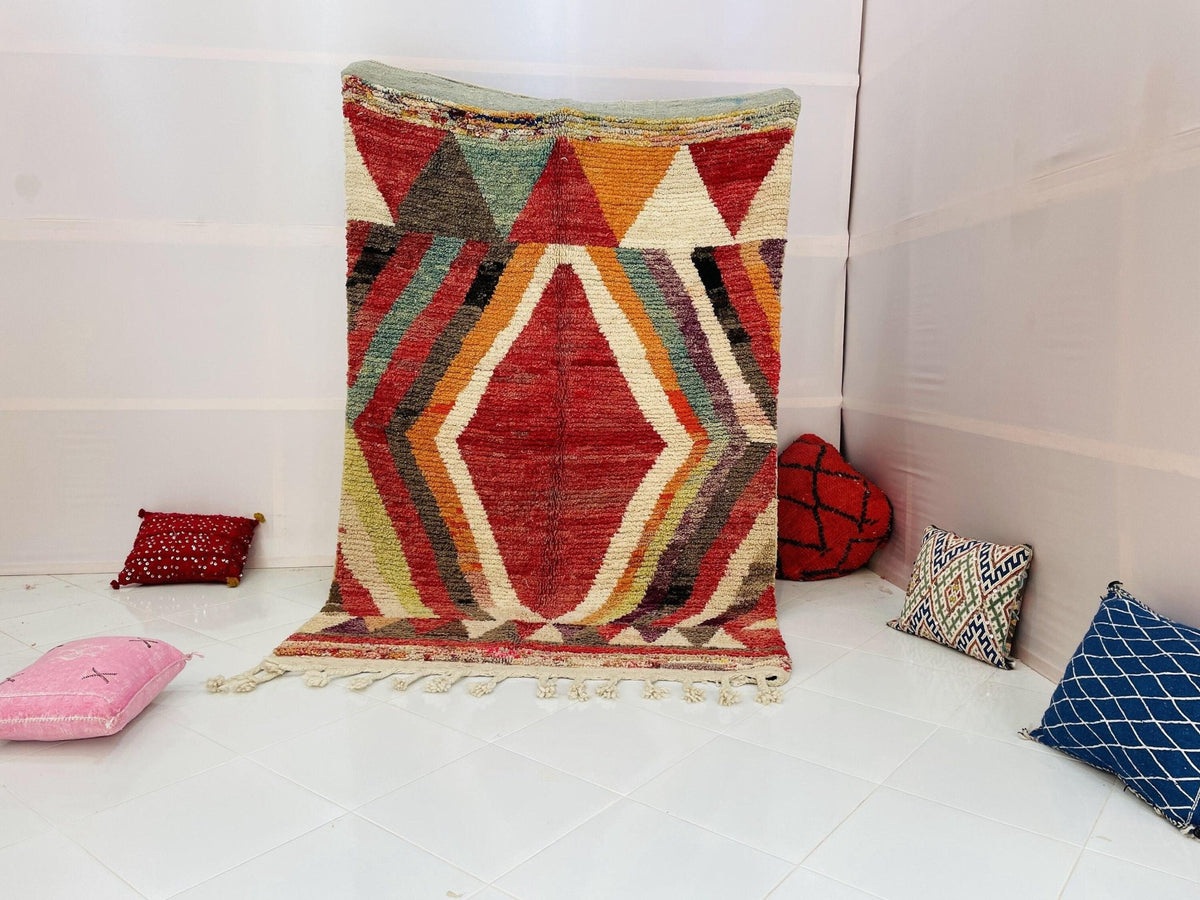 Lifestyle shot of a red and pink geometric Moroccan rug with bohemian style.