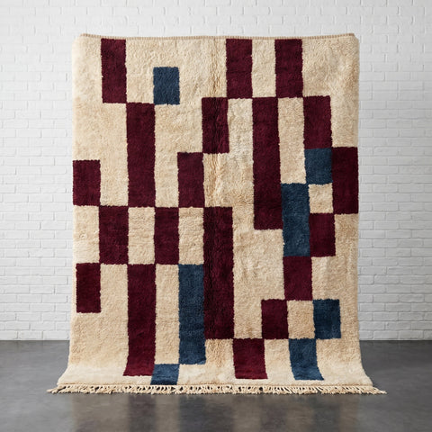 Front view of a burgundy Moroccan rug featuring geometric patterns and fringe edges.