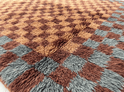 Close-up detail of a burgundy checkered Moroccan rug showcasing its textured surface and geometric patterns.