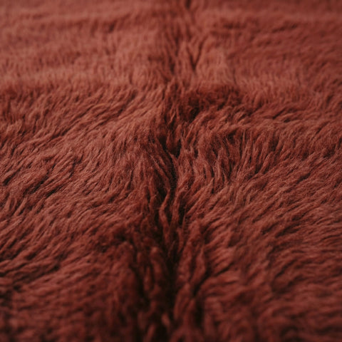 Close-up detail of the textured surface of the burgundy red Moroccan rug.