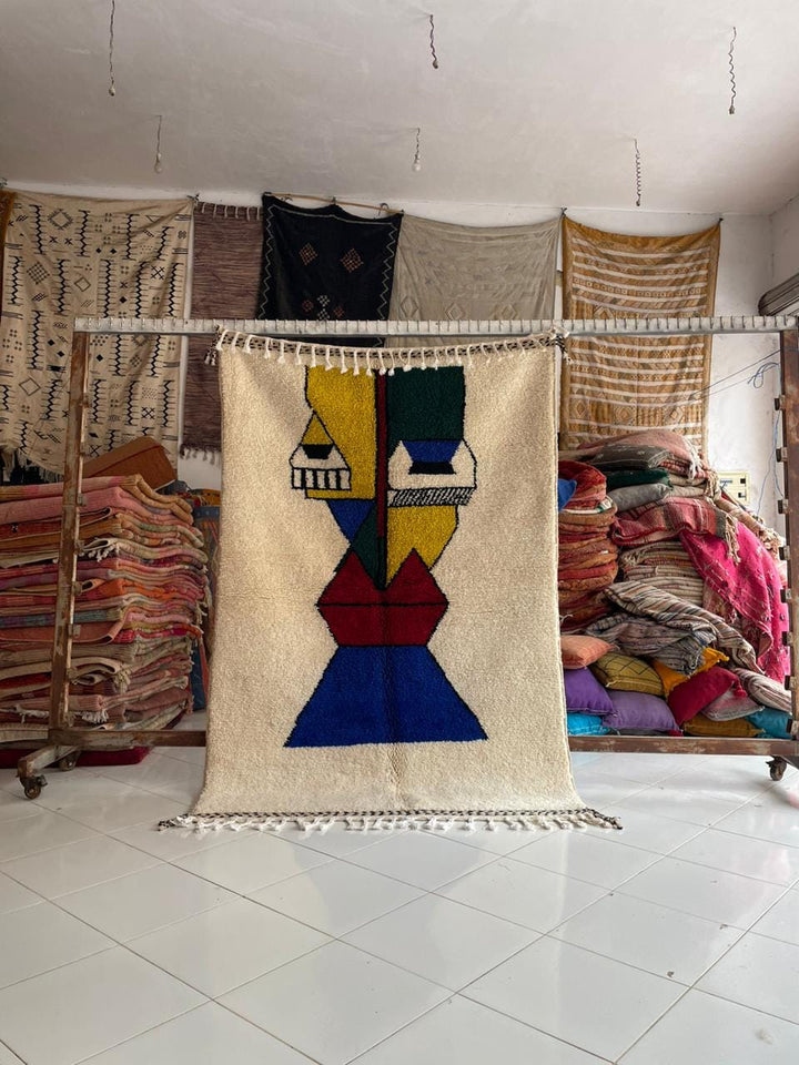Lifestyle shot of a colorful vintage Moroccan rug featuring abstract designs and fringe edges.