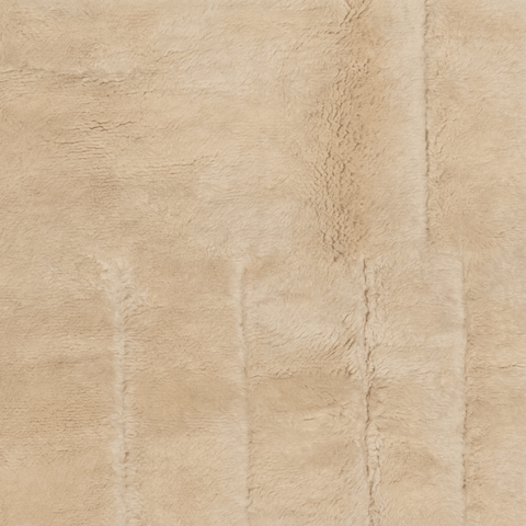 Close-up detail of a cream tufted rug highlighting fringe detail and soft texture.