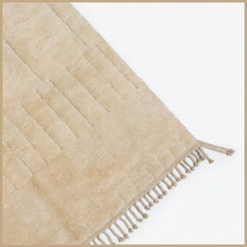 Lifestyle view of a cream tufted rug with a modern design in a natural environment.