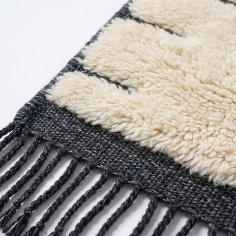 Front view of a cream tufted Moroccan rug showcasing a striped pattern on a studio background.