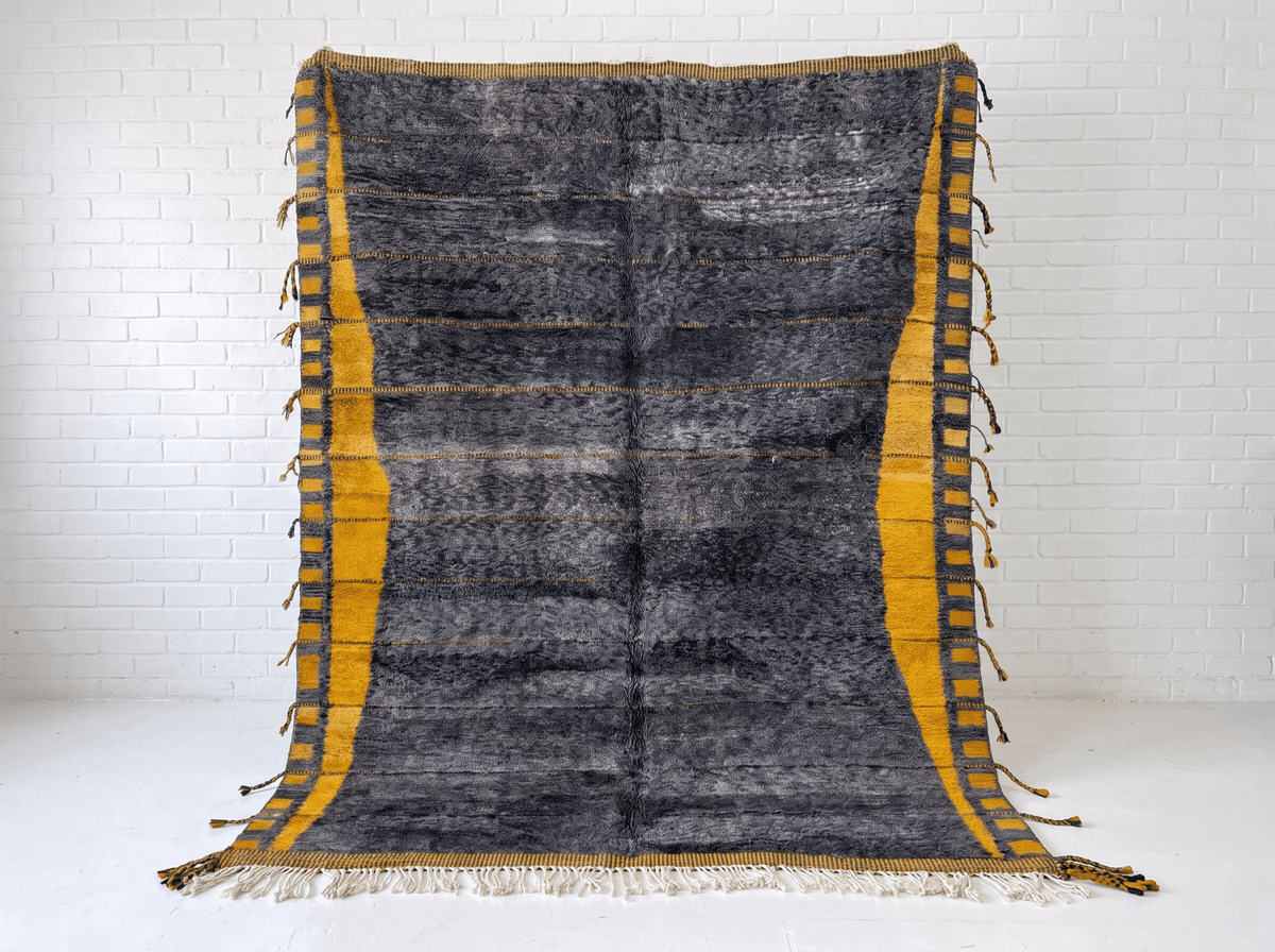 Front view of the dark grey Moroccan rug with fringe edges on a white background.