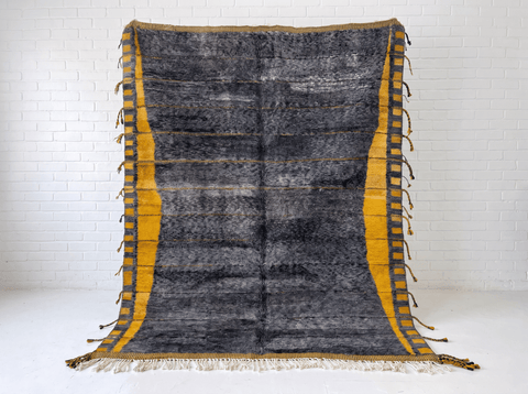 Front view of the dark grey Moroccan rug with fringe edges on a white background.