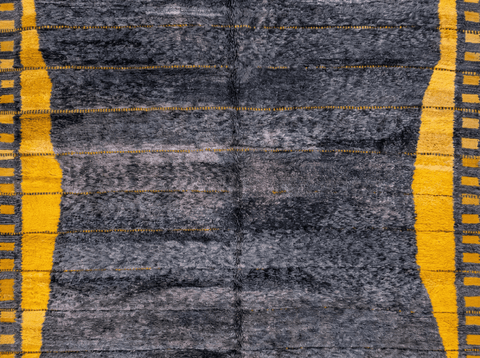 Close-up detail of the textured surface of the dark grey Moroccan rug on a white background.