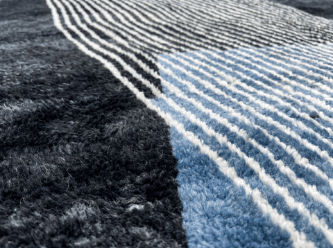 Close-up of the deep charcoal rug's striped pattern and soft fibers highlighting its texture.