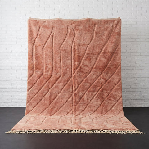 Front view of the dusty rose pink Moroccan rug featuring fringe edges.