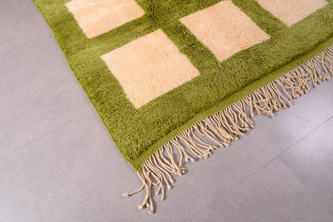 Front view of the olive green Moroccan rug with a geometric pattern and fringe detailing.