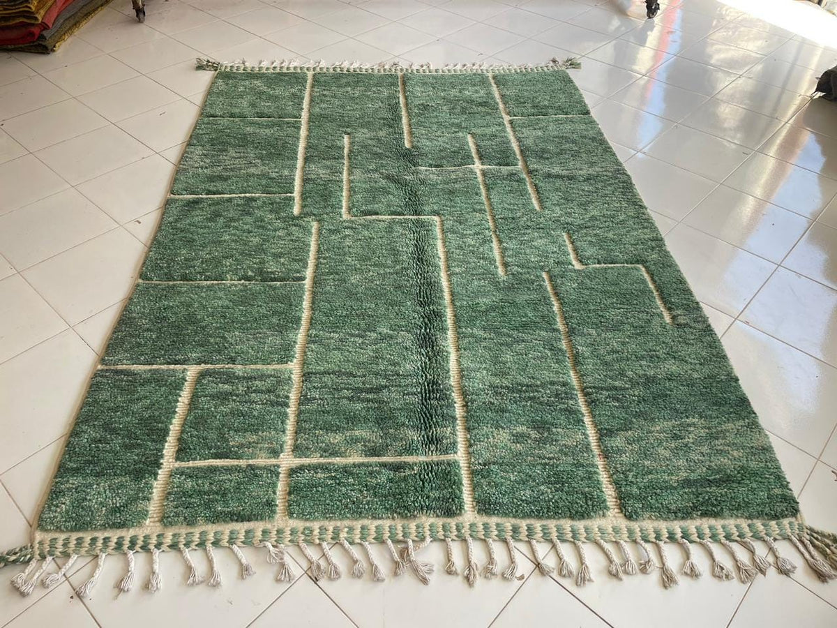 Top view of a green vintage Beni Ourain Moroccan rug showcasing its geometric design and fringe edges.