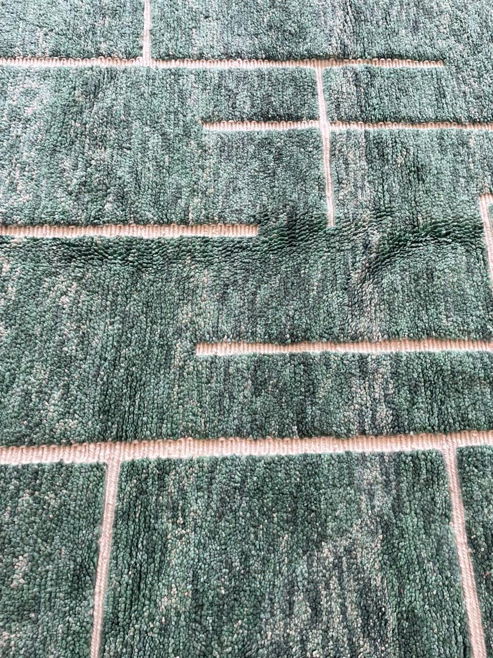 Close-up detail of the textured surface and stitch details on the green vintage Beni Ourain Moroccan rug.
