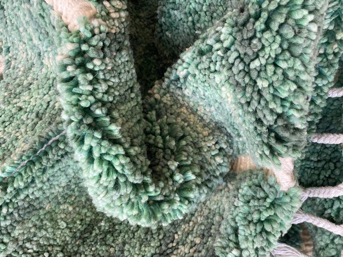 Close-up detail of the textured surface and line details on the green vintage Beni Ourain Moroccan rug.