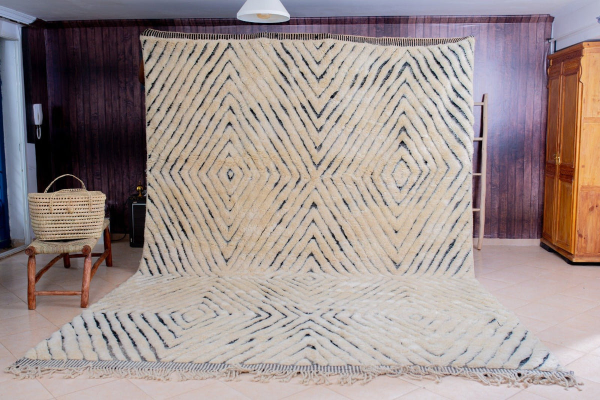 Lifestyle view of a cream geometric Moroccan rug featuring large geometric patterns in beige and black.