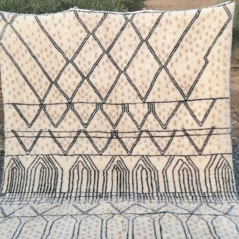 Front view of a cream checkered Moroccan rug with beige and black geometric patterns and fringe edges.