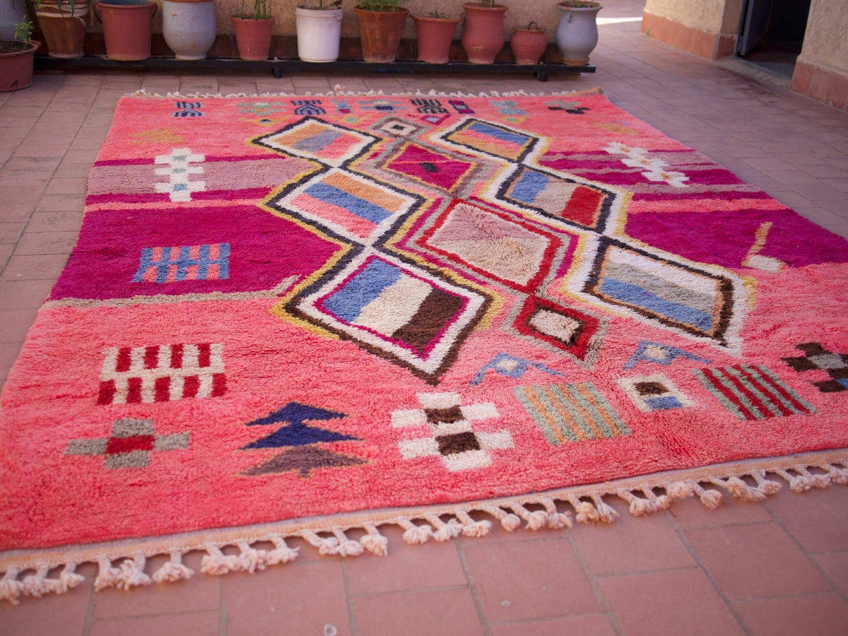 Close-up detail of a pink Moroccan rug showcasing soft shag and artistic design.