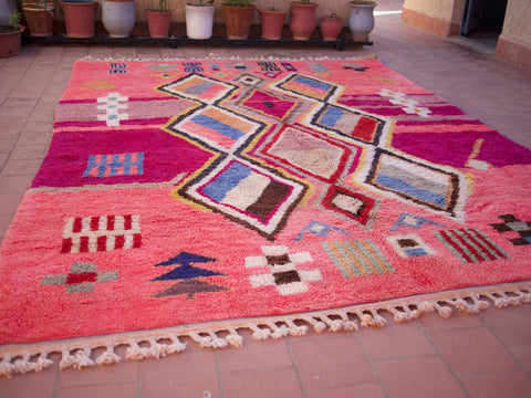 Close-up detail of a pink Moroccan rug showcasing soft shag and artistic design.