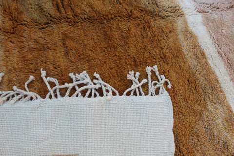 Detail close-up of the white and brown rug displaying an intricate design.