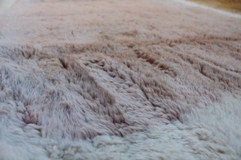 Detail close-up of the pattern on the brown and cream Moroccan rug.