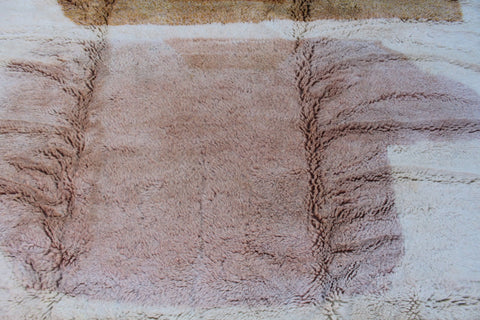 Detail close-up of the pink and cream Moroccan rug with a soft texture.