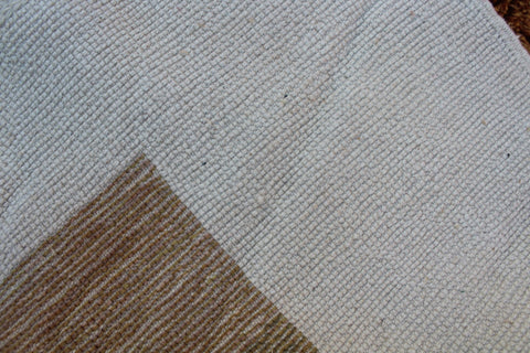 Detail close-up of the white and brown rug emphasizing its textured surface.