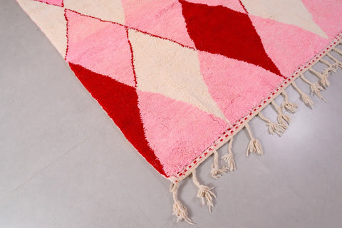 Detail close-up of the pink Beni Ourain rug featuring fringe edges in a studio setting.